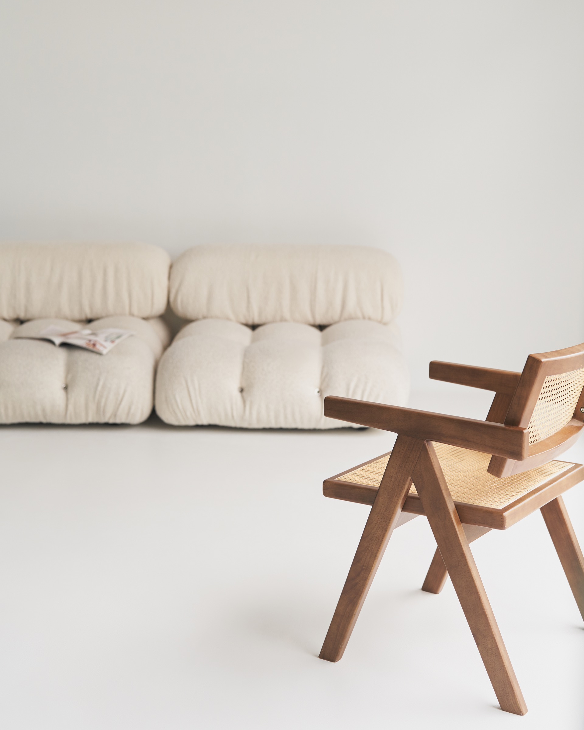 Cream studio seating area with warm daylight and white backdrop